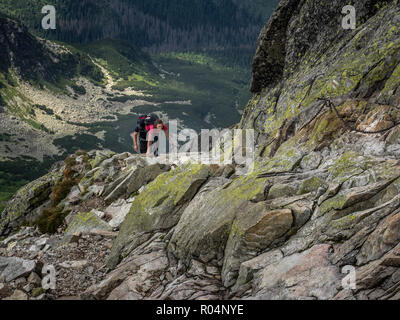 Dame scrambling sur Swinica, 2301m, à l'aide de chaînes métalliques, sur la frontière polonaise et slovaque dans les Tatras, Pologne, Europe Banque D'Images