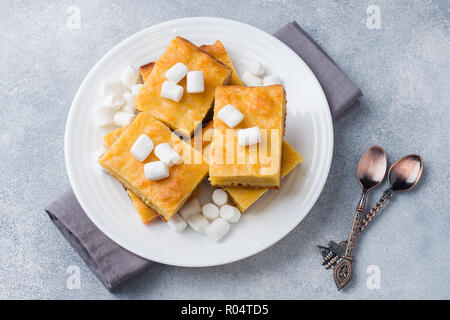 De délicieux morceaux de tarte à la citrouille avec de la guimauve et les noix sur une plaque Banque D'Images