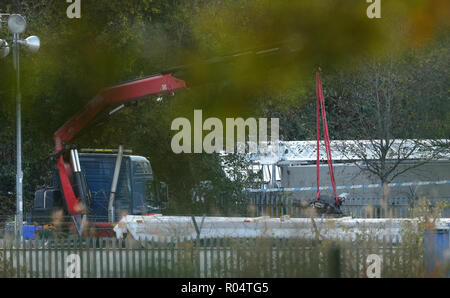 Une grue se déplace une partie de l'épave de l'hélicoptère survenu à Leicester City Football Club. Banque D'Images