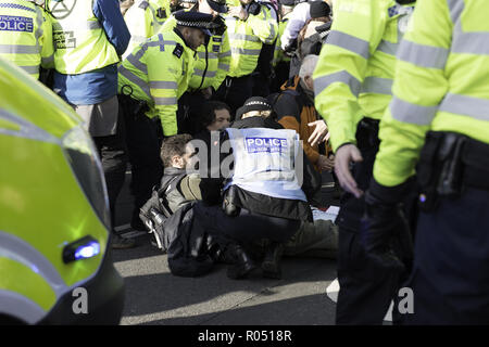 London, Greater London, UK. 31 octobre, 2018. Les agents de police sont vu la tenue d'un activiste qui était couché sur la route pendant la manifestation.La nouvelle rébellion Extinction Groupe, préoccupés par le changement climatique, appelle à un règlement pacifique de désobéissance civile de masse pour mettre en surbrillance les politiciens' manque d'engagement et d'action concernant les questions environnementales. Les militants se sont réunis à la place du Parlement et a bloqué la route pendant deux heures. La manifestation regroupait des conférenciers tels que le Greta Thunberg, Caroline Lucas, et George Monbiot. Conformément à l'extinction de rébellion 15 personnes ont été arrêtés dans la p Banque D'Images