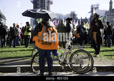 London, Greater London, UK. 31 octobre, 2018. Activiste environnemental vu portant un gilet rébellion extinction pendant la manifestation.La nouvelle rébellion Extinction Groupe, préoccupés par le changement climatique, appelle à un règlement pacifique de désobéissance civile de masse pour mettre en surbrillance les politiciens' manque d'engagement et d'action concernant les questions environnementales. Les militants se sont réunis à la place du Parlement et a bloqué la route pendant deux heures. La manifestation regroupait des conférenciers tels que le Greta Thunberg, Caroline Lucas, et George Monbiot. Conformément à l'extinction de rébellion 15 personnes ont été arrêtés dans la protestation. Banque D'Images