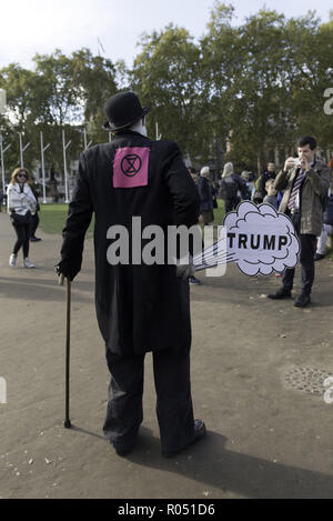 London, Greater London, UK. 31 octobre, 2018. Vu manifestant vêtu d'un costume de Charlie Chaplin tout en tenant une pancarte pendant la manifestation.La nouvelle rébellion Extinction Groupe, préoccupés par le changement climatique, appelle à un règlement pacifique de désobéissance civile de masse pour mettre en surbrillance les politiciens' manque d'engagement et d'action concernant les questions environnementales. Les militants se sont réunis à la place du Parlement et a bloqué la route pendant deux heures. La manifestation regroupait des conférenciers tels que le Greta Thunberg, Caroline Lucas, et George Monbiot. Conformément à l'extinction de rébellion 15 personnes ont été arrêtées en th Banque D'Images