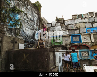 Manille, Philippines. 1er novembre 2018. Une femme qui à l'aide d'une échelle en bois pour rendre visite à son parent décédé au cimetière public de Navotas.Des millions de Philippins troupeau aux cimetières à travers le pays pour rendre visite à leurs défunts amoureux. Payer leurs respects à des êtres chers qui sont morts. C'est la tradition et la culture philippine. Credit : Josefiel Rivera SOPA/Images/ZUMA/Alamy Fil Live News Banque D'Images