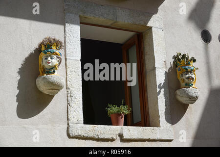 Taormina, Italie. 06 Sep, 2018. 06.09.2018, Italie, Taormina : têtes en céramique (Testa di Moro) représentant une femme et un homme sont attachées à une fenêtre sur une maison dans le village de montagne de Castelmola. La poterie traditionnelle sicilienne, promenades retour à une légende pendant le règne des Sarrasins sur la Sicile. Crédit : Alexandra Schuler/dpa | dans le monde d'utilisation/dpa/Alamy Live News Banque D'Images