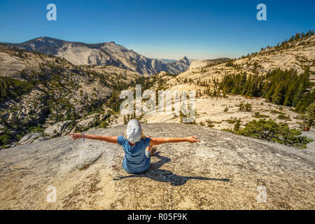 Femme enthousiaste randonnées détente à Olmsted Point et à la côté nord demi-dôme. Randonneur fatigué couché au repos à l'extérieur prenant une pause de la randonnée. Yosemite National Park, California, USA Banque D'Images