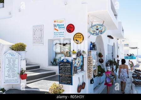 Santorin, GRÈCE - AOÛT 2018 : Femme avec des enfants sont à pied le long de la rue étroite à la ville de Thira. Ville de Thira est une capitale de l'île. Banque D'Images