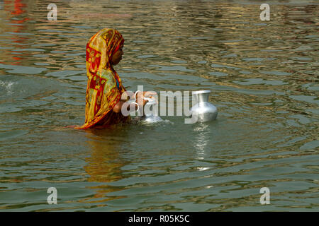 Une femme perçoit pichet d'eau d'une rivière à Sahapur. Sonargaon, Bangladesh, Narayanganj. Banque D'Images
