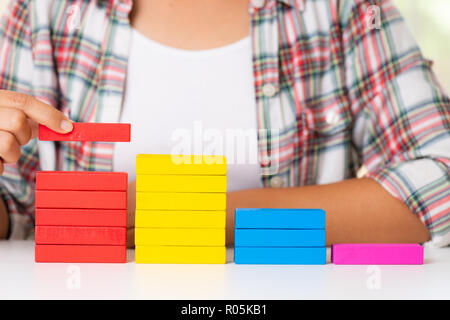 Concept de la fondation du succès. Les femmes part mettre les blocs en bois coloré en forme d'un escalier Banque D'Images