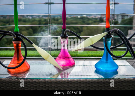 Trois couleurs hookahs sur table dans un salon à narguilé dans une journée. Banque D'Images