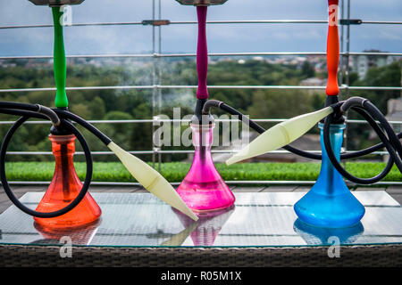 Trois couleurs hookahs sur table dans un salon à narguilé dans une journée. Banque D'Images