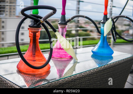 Trois couleurs hookahs sur table dans un salon à narguilé dans une journée. Banque D'Images