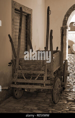 Un vieux chariot qui se lie à un cheval. La charrue et la lame sont chargés sur le chariot. Banque D'Images