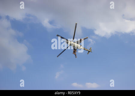 Hélicoptère de combat sur ciel bleu avec des nuages blancs. Vue depuis le bas. Banque D'Images