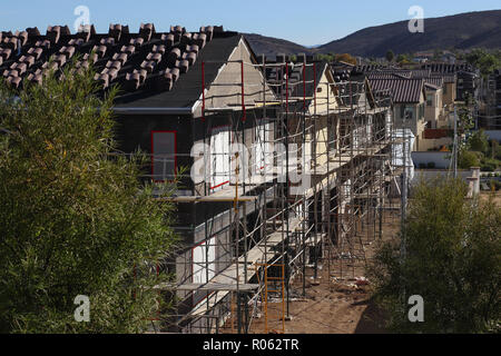 Plusieurs nouvelles maisons familiales de deux étages en construction et entouré par un échafaudage dans un neighorhood ; tuiles empilées, de lignes diagonales. Banque D'Images