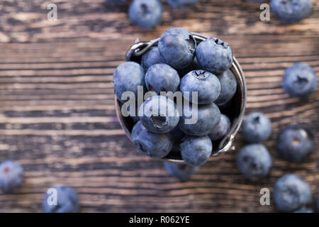 Grand Bleu Les bleuets éparpillés sur la table et se trouve dans un seau Banque D'Images