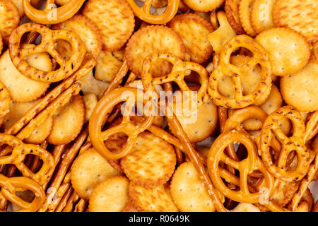 Une photo prise à la verticale d'un grand nombre de sel des craquelins, des bâtons, des bretzels, et poissons, un mix tourné à partir du haut, la texture des collations d'aliments de préparation rapide Banque D'Images