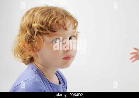 Un 'Annie' -sosie une très jolie portrait jeune garçon quelque peu pris au dépourvu par le photographe- curly cheveux rouges et une petite part rejoindre h Banque D'Images