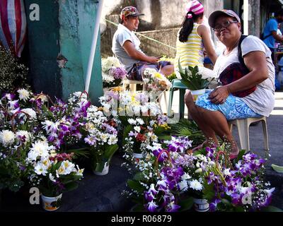 ANTIPOLO CITY, PHILIPPINES - 31 octobre 2018 : Un vendeur vend des fleurs aux familles qui visitent les tombes de leurs proches morts sur tous les Saints et tous les S Banque D'Images