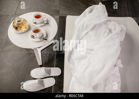 Vue rapprochée sur un bord de la piscine avec service à thé et un peignoir à l'intérieur Banque D'Images