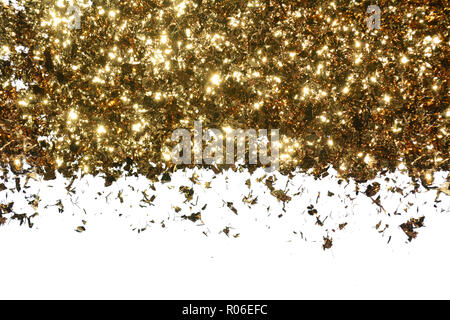Flocons d'or sur un fond blanc. Frontière de paillettes brillantes lumineuses Banque D'Images
