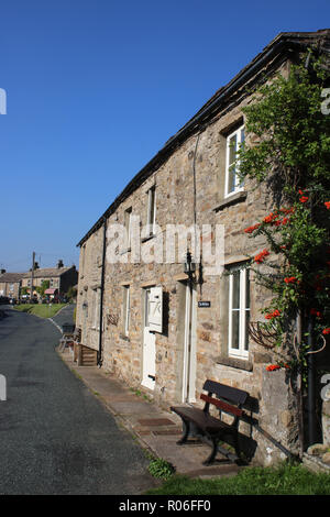 Holiday cottages en bois avec l'extérieur sur la route sur le côté de la route principale traversant Muker dans Swaledale, Yorkshire Dales, North Yorkshire, UK. Banque D'Images