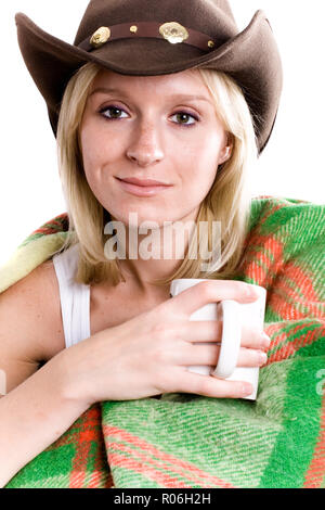 Belle fille dans un chapeau de cowboy avec tasse de thé enveloppé dans un plaid gros plan sur wite background Banque D'Images