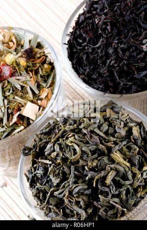 Trois sortes de thé sec en gros plan sur fond paille lunettes Banque D'Images