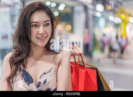 Happy young woman with shopping bags in mall Banque D'Images