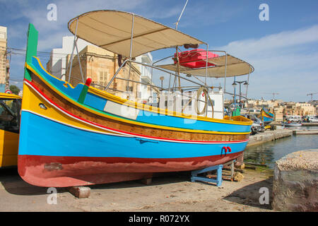 Bateaux traditionnels aux yeux peints dans village de pêcheurs de Marsaxlokk luzzu, Malte en journée ensoleillée Banque D'Images