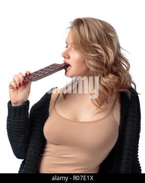 Belle jeune femme de manger du chocolat. Jeune blonde au maquillage naturel s'amuser et manger du chocolat isolé sur fond blanc. Banque D'Images