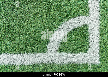 Coin du terrain de football avec gazon artificiel vert et des lignes blanches Banque D'Images