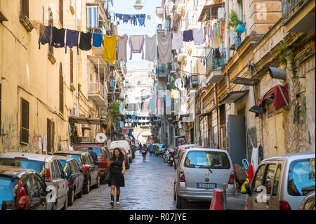 NAPLES, ITALIE - CIRCA Octobre 2017 : Les vêtements pendent à lignes tendues sur blanchisserie des piétons circulent sur les rues étroites du centre-ville historique Banque D'Images