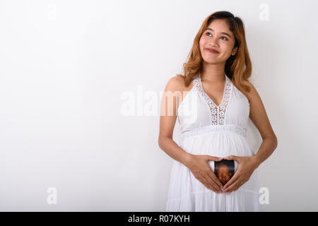 Portrait de jeune femme enceinte asiatique tout en rendant la pensée Banque D'Images