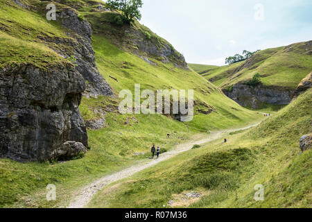 Randonneurs sur le chemin dans la grotte calcaire Dale, près de Castleton, Derbyshire, parc national de Peak District, England, UK Banque D'Images