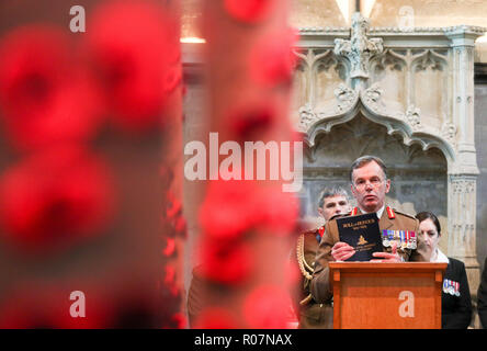 Le Lieutenant-général Sir Andrew Gregory, le maître canonnier de St James's Park, lit un article de l'Artillerie royale du rouleau d'honneur de l'Armistice, contenant les noms de leurs camarades de la Première Guerre mondiale, dans la chapelle du matin à l'intérieur de la cathédrale de Salisbury, Wiltshire. Banque D'Images