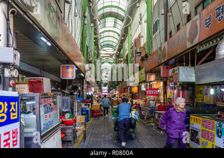 Vue le long d'une longue allée bordée de stands dans le marché couvert, Bupyeong Marché Khangtong à Busan, Corée du Sud. Banque D'Images