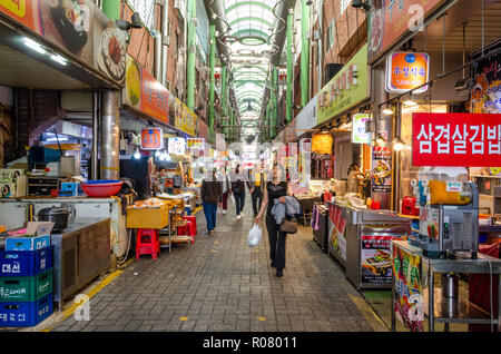 Vue le long d'une longue allée bordée de stands dans le marché couvert, Bupyeong Marché Khangtong à Busan, Corée du Sud. Banque D'Images