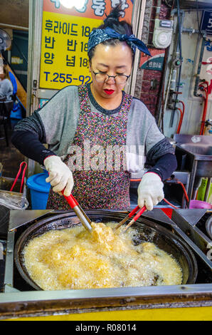 Une dame coréenne cuisiniers fried chicken dans Kkangtong Bupyeong Market à Busan, Corée du Sud. fried chicken est un populaire, bon marché et savoureuse cuisine de rue. Banque D'Images