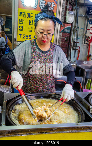 Une dame coréenne cuisiniers fried chicken dans Kkangtong Bupyeong Market à Busan, Corée du Sud. fried chicken est un populaire, bon marché et savoureuse cuisine de rue. Banque D'Images