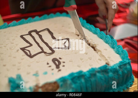 La coupe du gâteau de baptême catholique : une célébration très sincères parmi les gens qui croient en cette religion. Banque D'Images