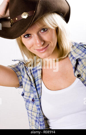 Closeup portrait de jolie femme occidentale en chemise et chapeau de cow-boy Banque D'Images