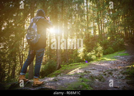 Un voyageur-photographe observe le coucher du soleil sur la forêt et les montagnes dans le Carpates ukrainiennes. L'Ukraine, les Carpates. Le 25 septembre 2018. Banque D'Images