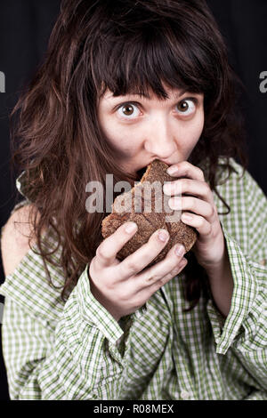 Portrait d'un pauvre mendiant femme manger un morceau de pain Banque D'Images