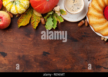 Toile d'automne avec des citrouilles, pommes, poires, de gâteaux, de café et de feuilles colorées sur fond de bois. Vue de dessus avec l'espace pour votre texte Banque D'Images