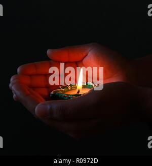 A girl holding allumé diya dans sa main afin de célébrer le diwali et dhanteras Banque D'Images