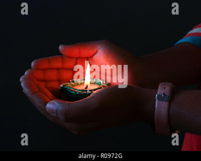 A girl holding allumé diya dans sa main afin de célébrer le diwali et dhanteras Banque D'Images