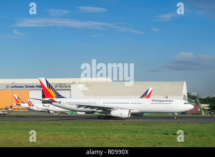 Plusieurs Philippine Airlines avec un Airbus A330 à l'avant-plan, à l'aéroport international Ninoy Aquino. Banque D'Images