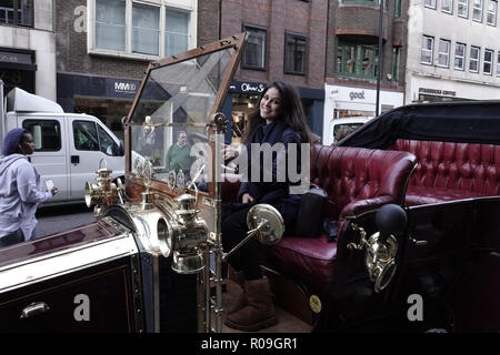 Londres, Royaume-Uni. 3 novembre 2018. Jeune femme obtient un goût de l'automobile du 19e siècle à l'Illinois Route 66 parrainé, Regent Street Motor Show, Westminster, London, UK Crédit : Motofoto/Alamy Live News Banque D'Images