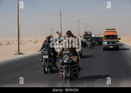 Nouveau Minya, Égypte. 06Th Nov, 2018. Les gens montent leurs motos comme ils la tête à l'tombes coptes lors des funérailles des victimes qui ont été tuées lors d'une attaque sur un bus transportant des chrétiens coptes au Monastère St Samuel un jour plus tôt. Le soi-disant état Islamique (EST) la terreur a pris la responsabilité de l'attentat qui a fait au moins sept personnes ont perdu la vie. Credit : Gehad Hamdy/dpa/Alamy Live News Banque D'Images