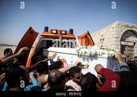 Nouveau Minya, Égypte. 06Th Nov, 2018. Les gens prennent un cercueil d'une ambulance à l'tombes coptes lors des funérailles des victimes qui ont été tuées lors d'une attaque sur un bus transportant des chrétiens coptes au Monastère St Samuel un jour plus tôt. Le soi-disant état Islamique (EST) la terreur a pris la responsabilité de l'attentat qui a fait au moins sept personnes ont perdu la vie. Credit : Gehad Hamdy/dpa/Alamy Live News Banque D'Images